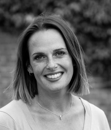 Black and white image of board member, Lisa Caldwell smiling towards the camera