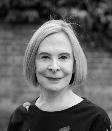 Black and white image of Board member, Suzanne McCarthy, smiling towards the camera